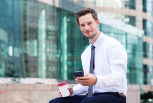 Caucasian businessman having his lunch break with coffee and mobile phone