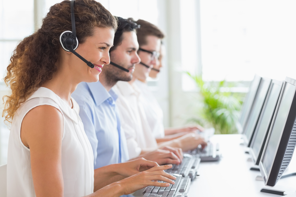 Customer service representatives working at desk in office