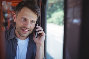 Handsome man talking on mobile phone in bus