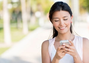 Portrait of a woman sending text message from her phone