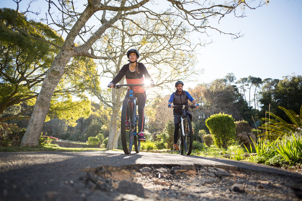 Smiling biker couple cycling on the countryside road