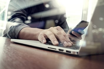 designer hand working and smart phone and laptop on wooden desk in office with london city background-2